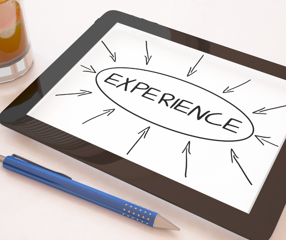 a tablet with the word experience written on it next to a cup of coffee and a pen